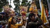Jika jempana dibawa dengan cara dipikul, sesajen dibawa dengan dijunjung di atas kepala. (Photo by Juni Kriswanto / AFP)