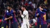Sergio Ramos berjalan di antara sejumlah pemain Barcelona yang merayakan kemenangan. Barcelona kini unggul sepuluh poin atas Atletico Madrid di puncak klasemen Liga Spanyol. (REUTERS/Sergio Perez)