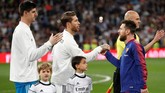 Kapten Real Madrid Sergio Ramos bersalaman dengan kapten Barcelona Lionel Messi sebelum pertandingan. (REUTERS/Juan Medina)