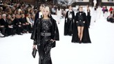 Sebagaimana kemampuan Lagerfeld mengejutkan banyak orang dengan ragam presentasinya, Grand Palais disulap menjadi sebuah desa cantik di pegunungan salju. Ada bangunan rumah berdinding kayu, asap mengepul dari cerobong asap, pohon cemara, dan salju berbelok ke arah deretan bangku-bangku panjang yang terbuat dari kayu. (REUTERS/Regis Duvignau)