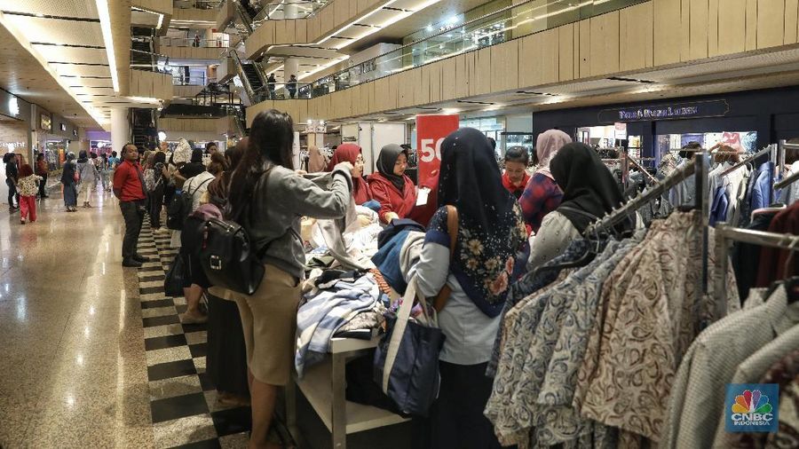 Pengunjung memelih pakaian yang dijual oleh salah satu tenant di Blok M Plaza, Jakarta, Rabu (6/3/2019). Untuk meningkatkan pengunjung manajemen Blok M Plaza merenovasi sejumlah fasilitas. (CNBC Indonesia/Andrean Kristianto)