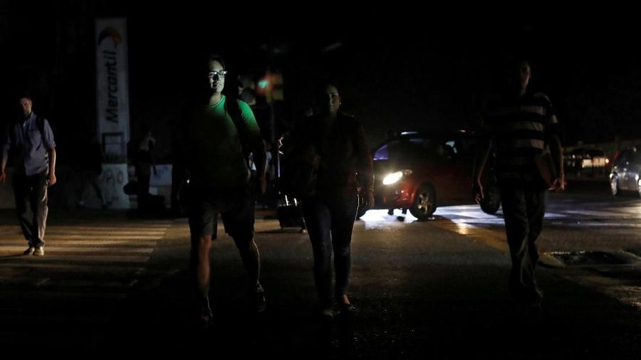 People cross a street during a blackout in Caracas, Venezuela March 7, 2019. REUTERS/Carlos Jasso