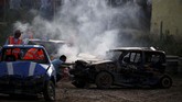 Seorang marshal menggunakan alat pemadam api berusaha mematikan mesin yang terbakar di akhir lomba yang diselenggarakan oleh Association of Motor Sports and Cars, di Ta 'Qali, Malta, pada Minggu (10/3). (REUTERS/Darrin Zammit Lupi)