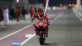 Andrea Dovizioso merayakan keberhasilan memenangi MotoGP Qatar 2019. (Photo by KARIM JAAFAR / AFP)