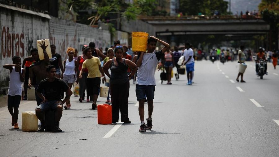 Akibat padamnya listrik memaksa warga Venezuela berebut mengambil air dari saluran limbah yang masuk ke Sungai Guaire di Caracas, Venezuela