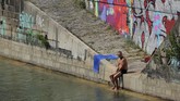 Warga bersantai di kanal Donaukanal, Wina Austria. Sebanyak 1,7 juta orang menghuni Wina. Kota ini memiliki banyak objek wisata yang menjadi magnet kedatangan 6.8 juta turis setiap tahunnya. (REUTERS/Heinz-Peter Bader)