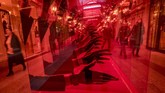 Orang-orang berjalan melewati iklan suatu toko jam di pusat perbelanjaan GUM di Moskow, Rusia. (Photo by Yuri KADOBNOV / AFP)