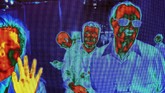 Bayangan panas orang-orang tertangkap oleh kamera pindai thermal FLIR (Forward-Looking Infrared). Mereka sedang berjalan dekat pameran FLIR di Pusat Konvensi Las Vegas. (Photo by DAVID MCNEW / AFP)