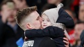 Pemain Rennes Benjamin Bourigeaud mencium anaknya setelah laga usai. (REUTERS/David Klein)
