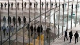 Bayangan orang-orang tercermin di tembok kaca Menara Post, atau markas besar pos dan logistik Jerman, Deutcsche Post DHL, ketika konferensi tahunan digelar di Bonn. (REUTERS/Wolfgang Rattay)
