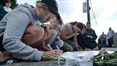 Warga menulis pesan di dekat bunga yang diletakkan di depan Masjid Wellington, Kilbirnie, Wellington, Selandia Baru, Sabtu (16/3/2019). Warga Wellington meletakkan bunga sebagai aksi solidaritas pascapenembakan di dua masjid di Christchurch pada Jumat (15/3). (ANTARA FOTO/Ramadian Bachtiar/wpa)