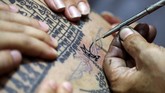 Yang boleh merajah Sak Yant hanya pendeta Buddha. Sebab setiap aksara yang ditorehkan di tubuh diyakini suci dan menjadi kekuatan spiritual. (REUTERS/Athit Perawongmetha)