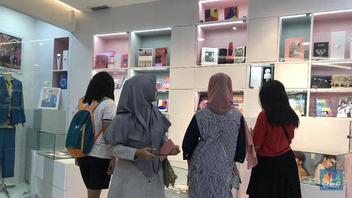 Fans K-Pop melihat-lihat ruang utama, dengan berbagai foto, album, poster, dan merchandise artis K-Pop di Kantor representatif dari Indonesia/SM Entertainment. (CNBC Indonesia/Linda Sari)