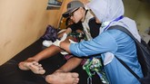 Seorang wisatawan korban selamat tanah longsor akibat gempa bumi mendapatkan perawatan medis oleh petugas di Puskesmas Bayan, Tanjung, Lombok Utara, NTB, Minggu (17/3). (ANTARA FOTO/Ahmad Subaidi)