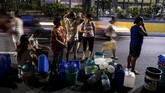 Setelah membeli galon dan ember, para warga langsung menuju truk-truk yang sengaja didatangkan pemerintah untuk membawa air bersih. (AFP Photo/Noel Celis)