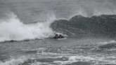 Peselancar asal Swedia, Pontus Hallin dan Lisa Blom mencoba meluncur dengan papan surfing dari bongkahan es. (Olivier MORIN / AFP)