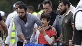 Zaed Mustafa (berkaus merah) kehilangan saudara dan ayahnya, Hamza dan Khalid Mustafa, dalam kejadian itu. Dia juga luka-luka terkena tembakan. (AP Photo/Mark Baker)