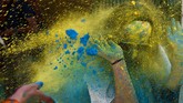 Dalam Festival Holi di Mumbai, India, juga digelar acara lomba lari dengan pesta lemparan bubuk berwarna di garis finisnya. (Indranil MUKHERJEE / AFP)