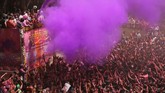 Pemuka agama di India menyemprotkan air berwarna-warni ke kerumunan orang sebagai penanda digelarnya Festival Holi di Kuil Swaminarayan, Ahmadabad, India, pada Rabu (20/3). (AP Photo/Ajit Solanki)