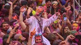Festival Holi juga diramaikan oleh turis penggemar fotografi dan seni budaya, seperti yang berlangsung di Pushkar, Rajasthan, India, pada Kamis (21/3). (Shaukat Ahmed / AFP)
