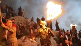 Orang-orang di Akre menadaki gunung dengan membawa obor. Mereka akan menyalakan api besar di puncak gunung itu. Gunung pun terlihat bercahaya. (REUTERS/Ahmed Jadallah)