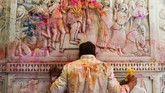 Di sebuah kuil di New Delhi, India, tubuh seorang pemeluk agama Hindu terkena serbuk warna-warni saat mengikuti festival Holi atau festival warna menyambut musim semi. (Photo by Dominique FAGET / AFP)
