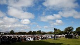 Di sekeliling jemaah diberi pagar pembatas. Warga non-muslim Selandia Baru yang hadir menyaksikan salat Jumat berkumpul di luar pagar. (REUTERS/Edgar Su)