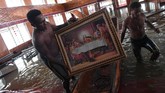 Lukisan perjamuan terakhir Yesus diamankan dari dalam gereja yang terendam banjir. (ANTARA FOTO/Zabur Karuru)