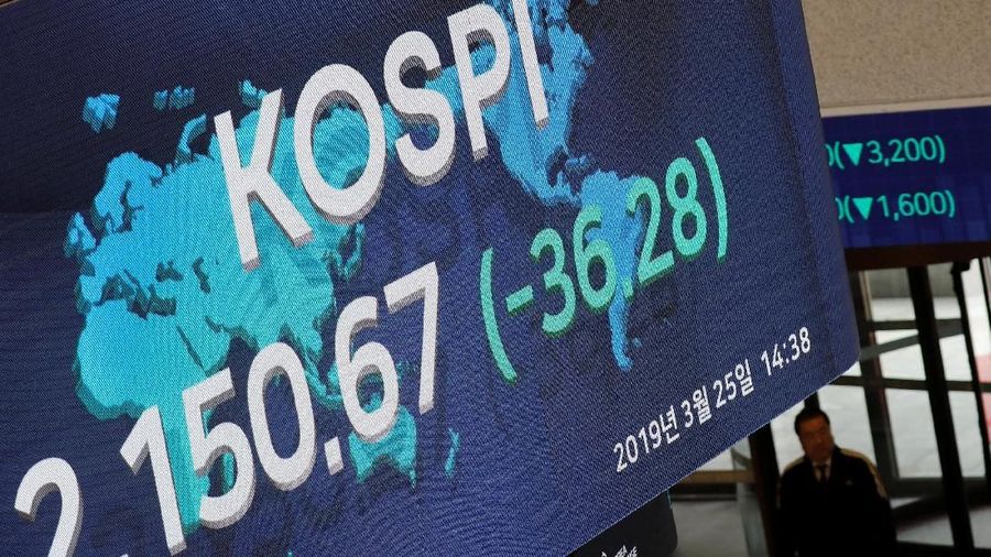 A woman walks past an electronic board showing the Korea Composite Stock Price Index (KOSPI) at the Korea Exchange in Seoul, South Korea, March 25, 2019.    REUTERS/Kim Hong-Ji