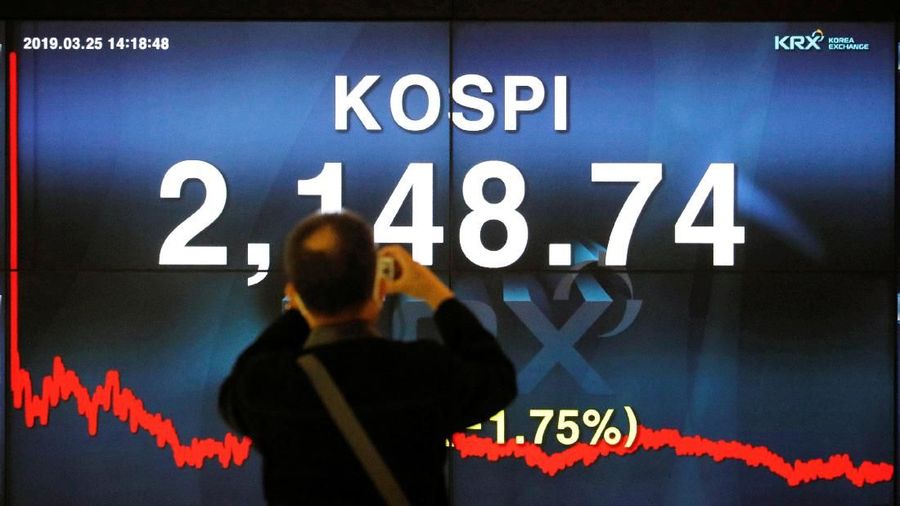 A woman walks past an electronic board showing the Korea Composite Stock Price Index (KOSPI) at the Korea Exchange in Seoul, South Korea, March 25, 2019.    REUTERS/Kim Hong-Ji