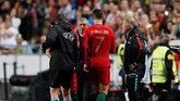 Cristiano Ronaldo berbicara dengan pelatih timnas Portugal Fernando Santos sebelum meninggalkan lapangan karena cedera hamstring. (REUTERS/Rafael Marchante)