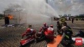 Petugas pemadam kebakaran melakukan simulasi pemadaman api saat hari pencoblosan. (CNNIndonesia/Adhi Wicaksono)