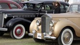 Seorang wanita berdiri di antara model lawas Buick berwarna hitam dan Rolls-Royce Silver Dawn pada acara ke-7 Cairo Classic Meet 2019 di Kairo, Mesir pada 23 Maret 2019. (REUTERS/Mohamed Abd El Ghany)