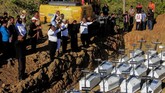 Warga melakukan ibadah ketika memakamkan jenazah korban banjir bandang Sentani yang dikuburkan secara massal di Pemakaman Umum Kampung Harapan Sentani, Jayapura, Papua, Rabu (27/3/2019). Sebanyak 20 jenazah yang belum teridentifikasi dikuburkan secara amassal. ANTARA FOTO/Gusti Tanati/wpa/ama.