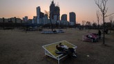 Pasangan duduk di suatu bangku di taman Yeouido sambil mengamati garis langit kota Seoul. Mengutip data pemerintah, media-media lokal melaporkan bahwa jumlah pasangan yang menikah menurun drastis dan mencapai titik terendah dalam 40 tahun. (AFP/Ed Jones)
