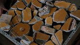 Puing-puing yang dulunya adalah lukisan dinding, hancur oleh guncangan alam, ditemukan dan dikumpulkan dalam salah satu penggalian. (REUTERS/Ciro De Luca)