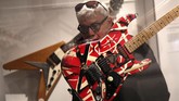 Seorang pria terlihat memeriksa gitar yang dibuat khusus untuk Eddie Van Halen, pendiri band Van Halen yang populer antara lain lewat 'Jump' serta 'Can't Stop Loving You'. (AP Photo/Seth Wenig)
