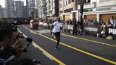 Usain Bolt tampak jauh meninggalkan kendaraan yang familier disebut mototaxi di Peru atau populer dengan sebutan bajaj di Indonesia. (AP Photo/Martin Mejia)
