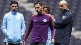 Manajer Manchester City Pep Guardiola memantau latihan bersama asisten, Mikel Arteta. Terlihat Bernardo Silva menendang bola di bawah pengawasan Guardiola. (Reuters/John Sibley)