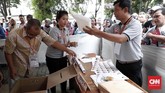 Petugas memeriksa kelengkapan semua alat dan berkas sebelum warga melakukan pencoblosan saat simulasi pemilihan suara Pemilu 2019. (CNNIndonesia/Safir Makki)
