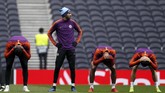 Winger Manchester City Riyad Mahrez berdiri saat ketiga rekan setimnya menunduk pada latihan terakhir jelang melawan Tottenham Hotspur di Stadion Tottenham Hotspur, London, Senin (8/4). (Reuters/John Sibley)