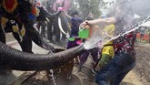 Secara tradisional ditandai dengan memberi hormat kepada para tetua dan menaburkan air di atas patung-patung Buddha di kuil-kuil setempat, saat ini Songkran berkembang menjadi pertarungan air yang heboh. (REUTERS/Soe Zeya)