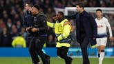 Manajer Tottenham Mauricio Pochettino (kanan) bersama petugas keamanan menghalau penyusup yang masuk ke lapangan dalam pertandingan melawan Man City. (Photo by Paul ELLIS / AFP)