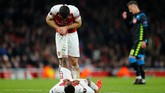 Sokratis Papastathopoulos membantu Ainsley Maitland-Niles untuk meredakan masalah di kaki. Arsenal menang 2-0 pada leg pertama dan akan bertamu ke markas Napoli pekan depan. (REUTERS/Eddie Keogh)