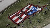 Penonton duduk di sekitar tribute untuk mendiang legenda balap MotoGP asal Amerika Serikat Nicky Hayden di Sirkuit Americas pada hari pertama MotoGP Amerika 2019, Jumat (12/4) siang waktu setempat. (AP Photo/Eric Gay)
