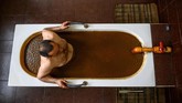Salah satunya adalah di Pusat Kesehatan Sehirli. Di sana tersedia bak mandi besar berisi minyak mentah yang siap menemani mandi Anda. (Photo by Mladen ANTONOV/AFP)