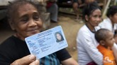 Seorang perempuan suku Polahi menunjukan KTP elektronik miliknya usai sosialisasi Pemilu. Pemimpin suku, Raja Babuta mengakui mereka telah memiliki KTP elektronik sejak 2012 karena diajak oleh salah seorang teman dari perkampungan warga. (ANTARA FOTO/Adiwinata Solihin)