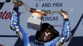 Alex Rins mengangkat trofi podium pertama MotoGP Amerika Serikat. Sukses itu menandai kemenangan perdana mereka di MotoGP sepanjang kariernya. (AP Photo/Eric Gay)