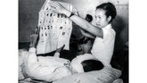 Seorang juru rawat sebagai wakil PPPS tengah melayani pemilih dengan membentangkan surat suara di Rumah Sakit Umum Rancabadak, Bandung 15 Desember 1955. (Sumber: ANRI)