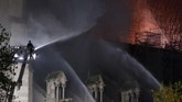 Asap terlihat mengepul keluar dari bagian atas katedral yang dibangun pada abad pertengahan tersebut. Api menjalar di samping dua menara lonceng. (REUTERS/Charles Platiau)